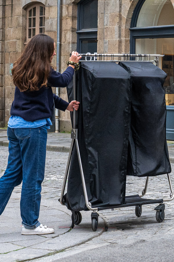 Commerciale poussant un Portant Pro Bag PRO dans une rue pavée