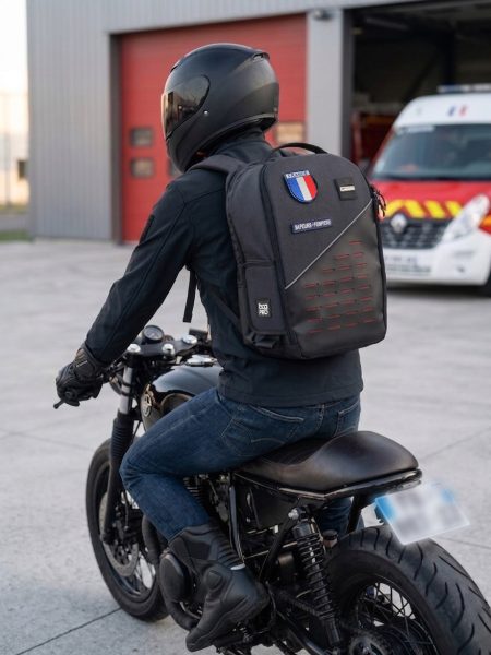 Photo du Sac à dos secours Echo 30 de Bag PRO, sur le dos d'un pompier arrivant à la caserne sur sa moto